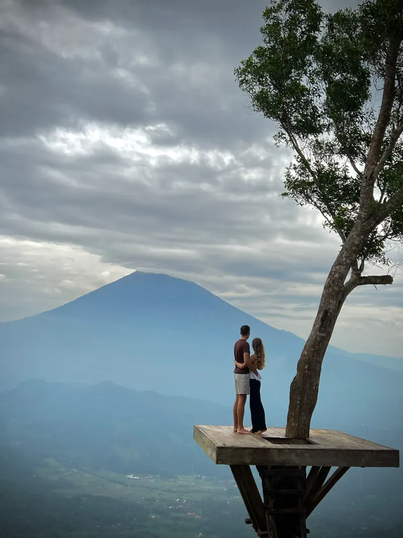 Couple sur une plateforme face au Mont Agung, point de vue à Bali en Indonésie